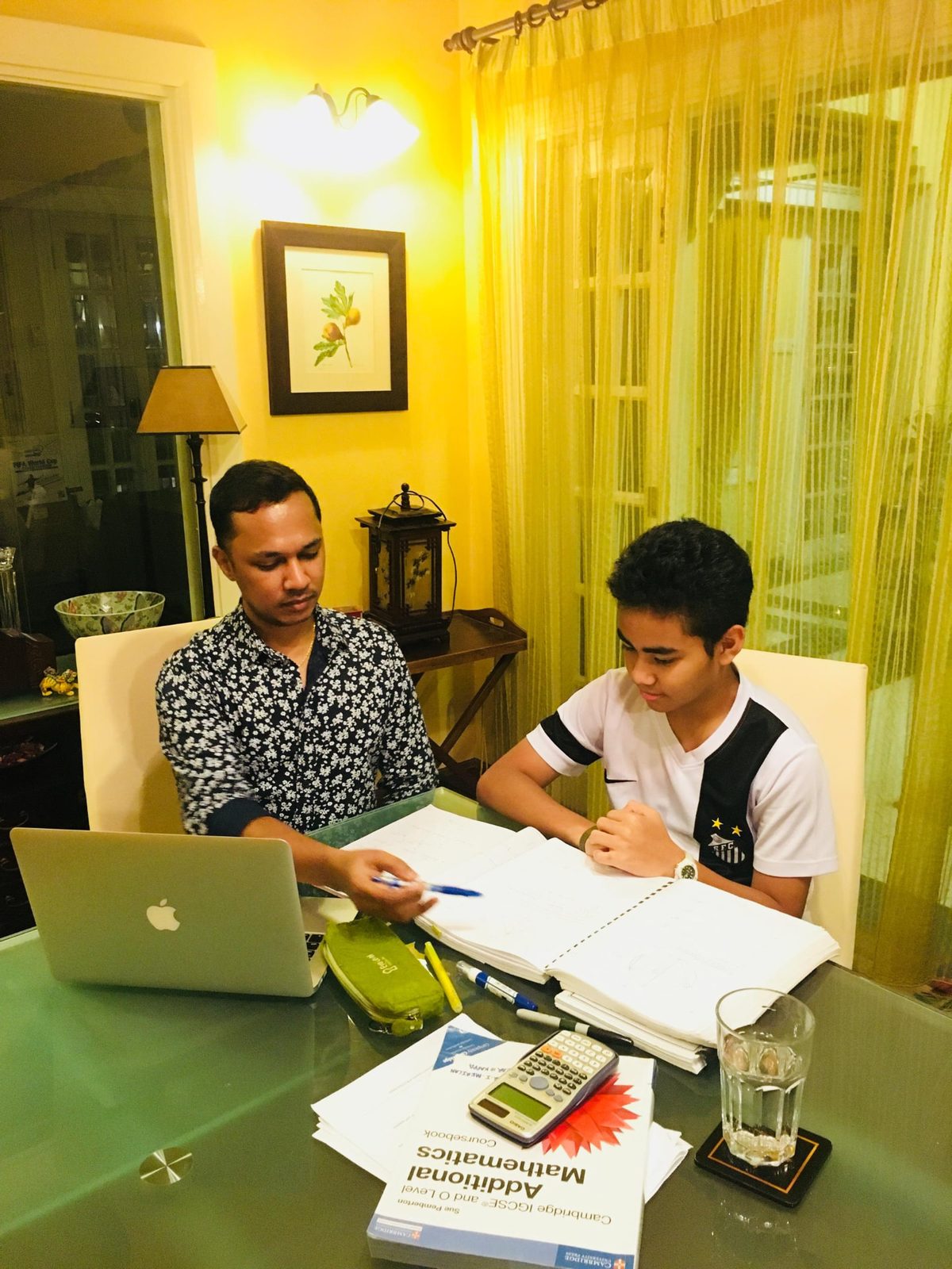 Mr Kumaraveelu explaining Mathematics to a student during a one-to-one home lesson